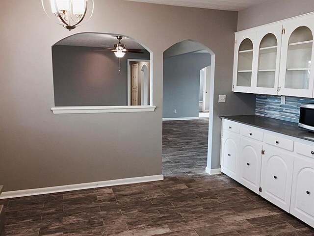503 Kingston Dr, Yukon, OK 73099 - kitchen with white cabinets, ceiling fan, dark countertops, glass insert cabinets, and dark wood-style flooring