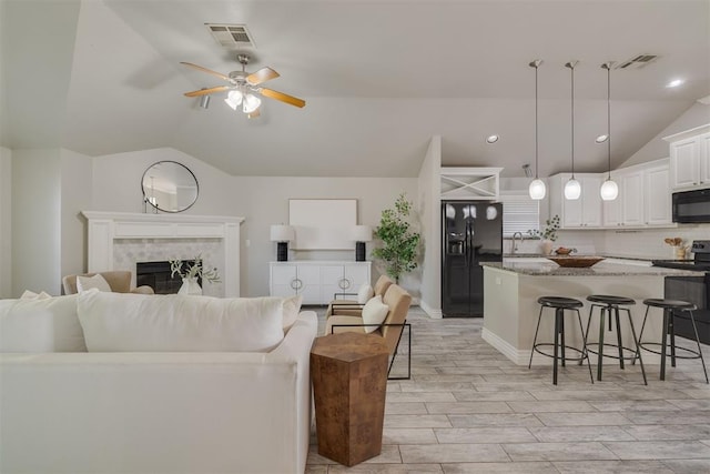 15924 Sky Run Dr, Edmond, OK 73013 - living room with ceiling fan, visible vents, lofted ceiling, and wood tiled floor