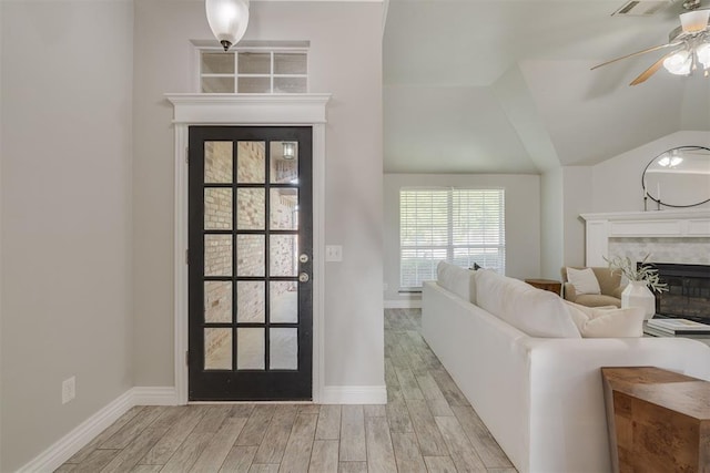 15924 Sky Run Dr, Edmond, OK 73013 - interior space with ceiling fan, baseboards, lofted ceiling, light wood-style floors, and a premium fireplace