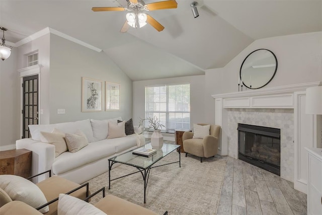 15924 Sky Run Dr, Edmond, OK 73013 - living area featuring crown molding, ceiling fan, a tiled fireplace, light wood-style flooring, and vaulted ceiling