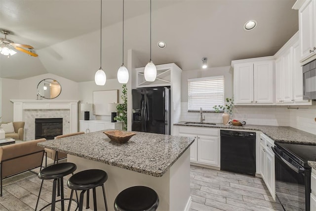 15924 Sky Run Dr, Edmond, OK 73013 - kitchen featuring ceiling fan, a sink, lofted ceiling, a kitchen island, and black appliances