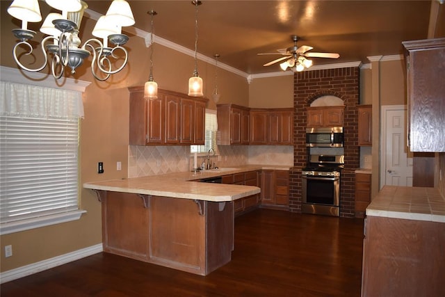 2297 Barrington Dr, Blanchard, OK 73010 - kitchen with a sink, a peninsula, tasteful backsplash, appliances with stainless steel finishes, and ceiling fan with notable chandelier