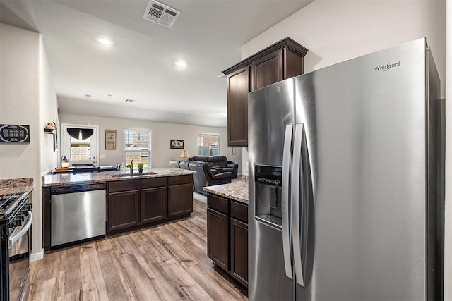 1105 NW 3rd St, Newcastle, OK 73065 - kitchen featuring visible vents, a sink, dark brown cabinetry, light wood-style floors, and stainless steel appliances