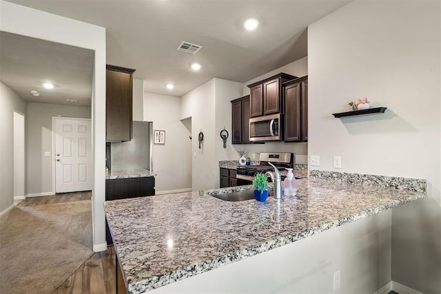 1105 NW 3rd St, Newcastle, OK 73065 - kitchen featuring light stone countertops, visible vents, dark brown cabinetry, dark wood-type flooring, and appliances with stainless steel finishes