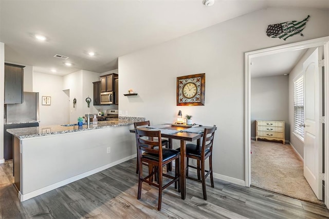 1105 NW 3rd St, Newcastle, OK 73065 - dining area featuring lofted ceiling, wood finished floors, visible vents, recessed lighting, and baseboards