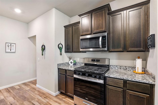 1105 NW 3rd St, Newcastle, OK 73065 - kitchen with appliances with stainless steel finishes, dark brown cabinets, light stone countertops, and light wood-type flooring