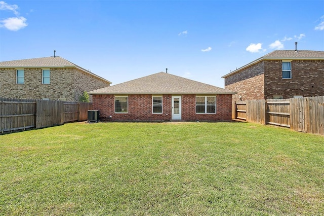 1105 NW 3rd St, Newcastle, OK 73065 - rear view of property featuring a lawn, central air condition unit, a fenced backyard, brick siding, and roof with shingles