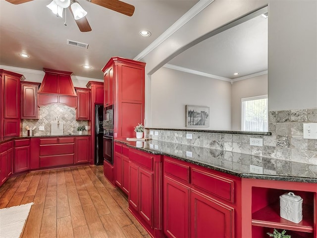 2105 SE 3rd St, Moore, OK 73160 - kitchen featuring a ceiling fan, custom exhaust hood, tasteful backsplash, reddish brown cabinets, and visible vents