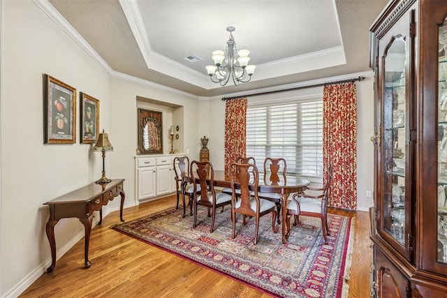 4608 Greystone Ct, Norman, OK 73072 - dining area featuring crown molding, light wood finished floors, a raised ceiling, a notable chandelier, and visible vents