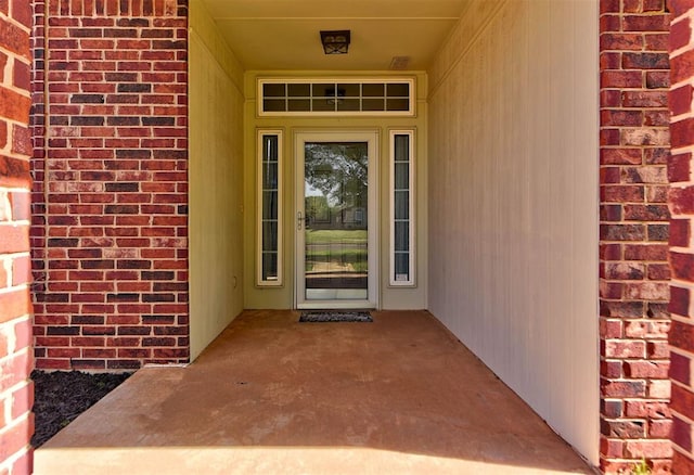 doorway to property with brick siding