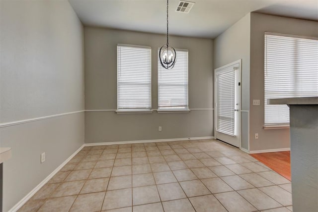 interior space featuring an inviting chandelier, light tile patterned flooring, visible vents, and baseboards