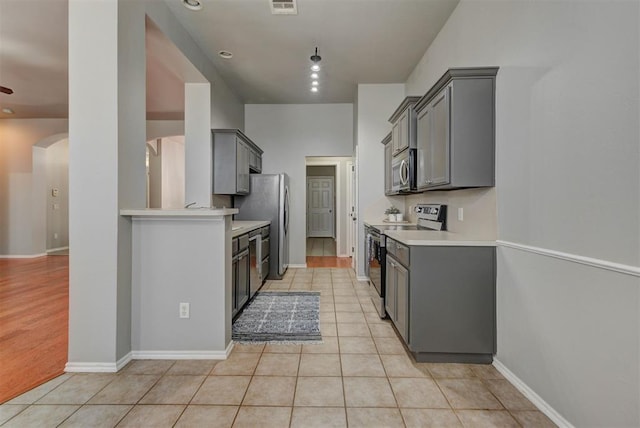 kitchen featuring light countertops, appliances with stainless steel finishes, and gray cabinets