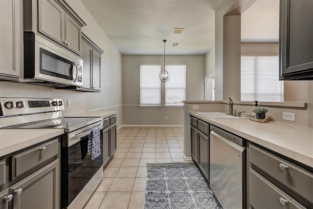 kitchen with light countertops, stainless steel appliances, visible vents, and a sink