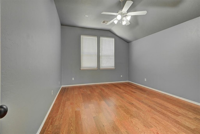 unfurnished room featuring lofted ceiling, a ceiling fan, wood finished floors, and baseboards