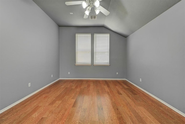 additional living space with a ceiling fan, wood finished floors, baseboards, lofted ceiling, and visible vents