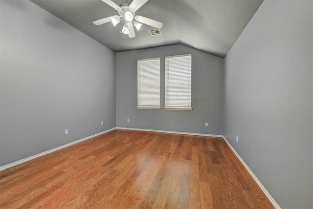 interior space featuring vaulted ceiling, baseboards, visible vents, a ceiling fan, and wood finished floors