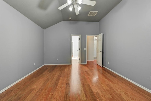 unfurnished bedroom with vaulted ceiling, wood finished floors, visible vents, and baseboards