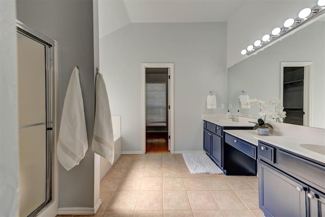 bathroom featuring a shower stall, vaulted ceiling, tile patterned floors, a sink, and double vanity