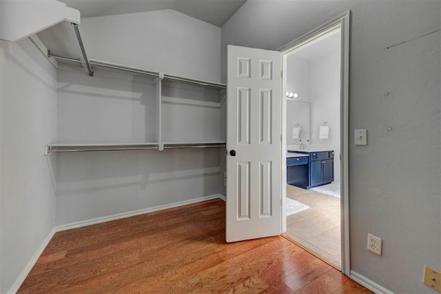 spacious closet featuring vaulted ceiling and wood finished floors