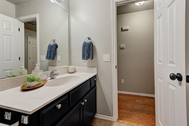 bathroom featuring baseboards, vanity, and wood finished floors