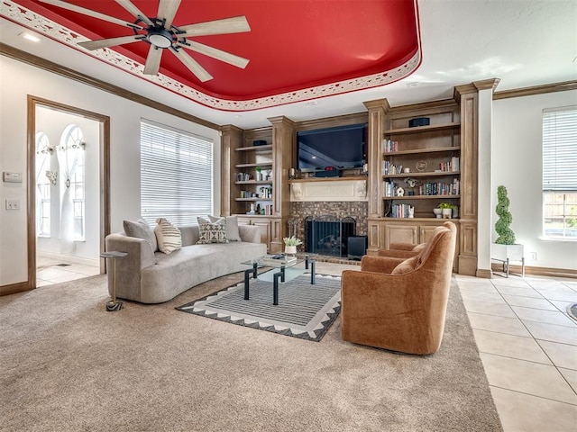 8016 NW 124th St, Oklahoma City, OK 73142 - living room featuring crown molding, a raised ceiling, a ceiling fan, light tile patterned flooring, and a fireplace