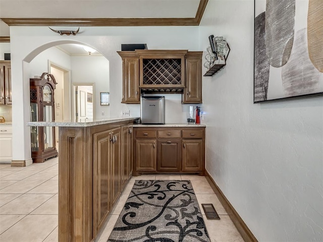 8016 NW 124th St, Oklahoma City, OK 73142 - kitchen with a peninsula, crown molding, light tile patterned floors, arched walkways, and baseboards