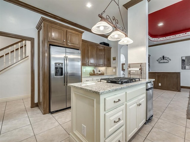 8016 NW 124th St, Oklahoma City, OK 73142 - kitchen with stainless steel appliances, light tile patterned floors, backsplash, light stone countertops, and arched walkways