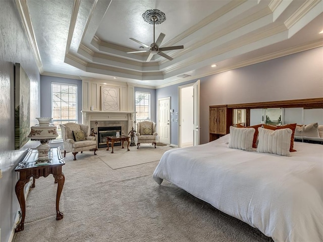 8016 NW 124th St, Oklahoma City, OK 73142 - bedroom featuring a tray ceiling, multiple windows, ornamental molding, light colored carpet, and a tile fireplace