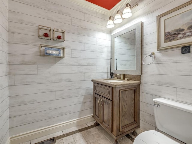 8016 NW 124th St, Oklahoma City, OK 73142 - bathroom with inlaid floor details, toilet, vanity, tile patterned floors, and wood walls