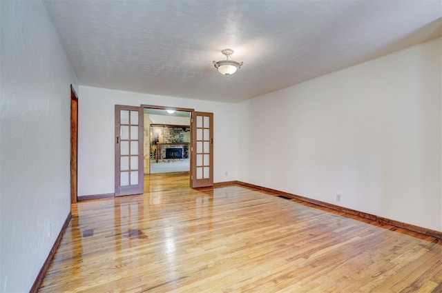 6205 S Choctaw Rd, Choctaw, OK 73020 - spare room featuring light wood finished floors, baseboards, french doors, and visible vents
