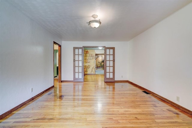 6205 S Choctaw Rd, Choctaw, OK 73020 - spare room featuring baseboards, french doors, light wood-style floors, and visible vents