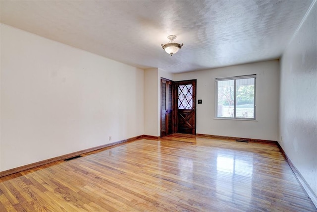 6205 S Choctaw Rd, Choctaw, OK 73020 - empty room featuring baseboards, light wood-style flooring, visible vents, and a textured ceiling
