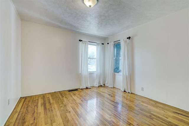 6205 S Choctaw Rd, Choctaw, OK 73020 - unfurnished room featuring wood finished floors, visible vents, and a textured ceiling