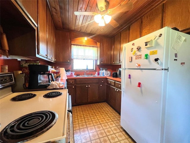 kitchen featuring a ceiling fan, a sink, white appliances, light floors, and wooden ceiling