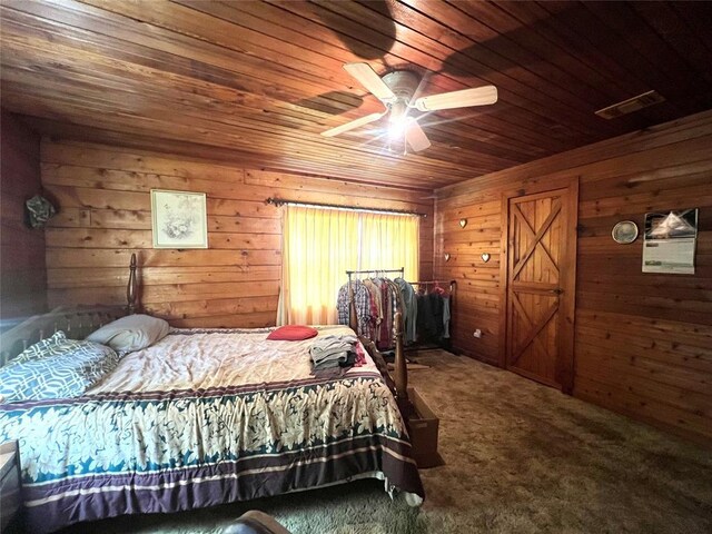 bedroom featuring carpet floors, visible vents, wood walls, and wooden ceiling