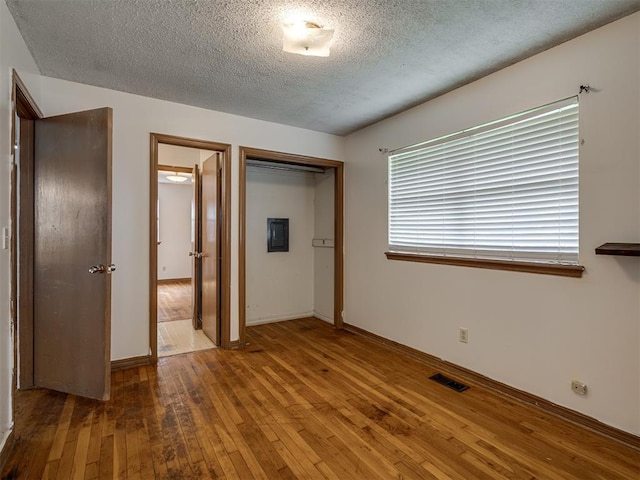 320 Willow Pl, Yukon, OK 73099 - unfurnished bedroom featuring visible vents, a closet, baseboards, a textured ceiling, and hardwood / wood-style flooring