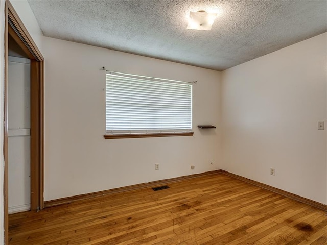 320 Willow Pl, Yukon, OK 73099 - unfurnished bedroom with baseboards, visible vents, light wood-style floors, and a textured ceiling