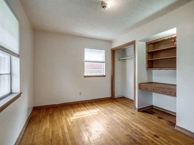 320 Willow Pl, Yukon, OK 73099 - unfurnished bedroom featuring hardwood / wood-style flooring, baseboards, a textured ceiling, and a closet