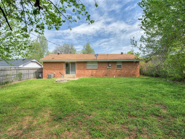 320 Willow Pl, Yukon, OK 73099 - back of house featuring a lawn, central AC unit, crawl space, and fence