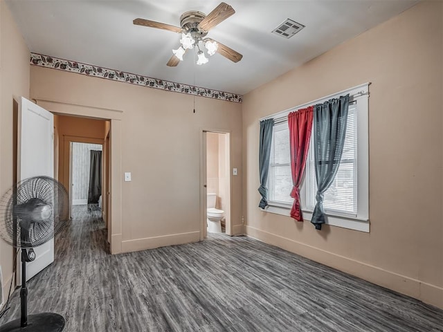 empty room featuring baseboards, a ceiling fan, wood finished floors, and visible vents