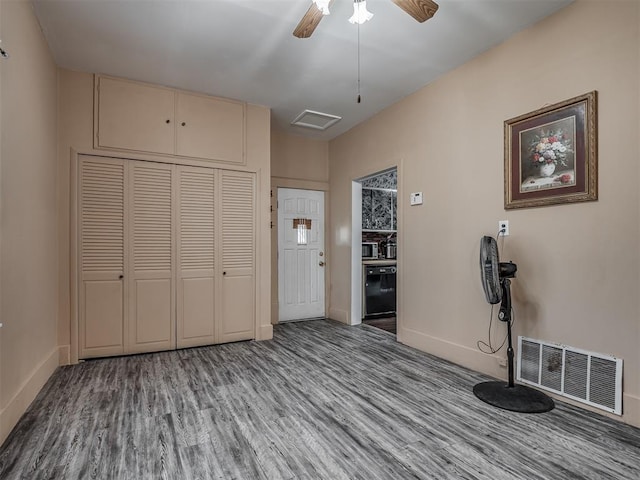foyer entrance featuring baseboards, wood finished floors, and visible vents