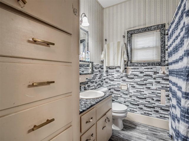 bathroom featuring backsplash, toilet, vanity, and wood finished floors