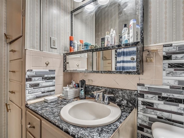 bathroom with wallpapered walls, tasteful backsplash, and vanity