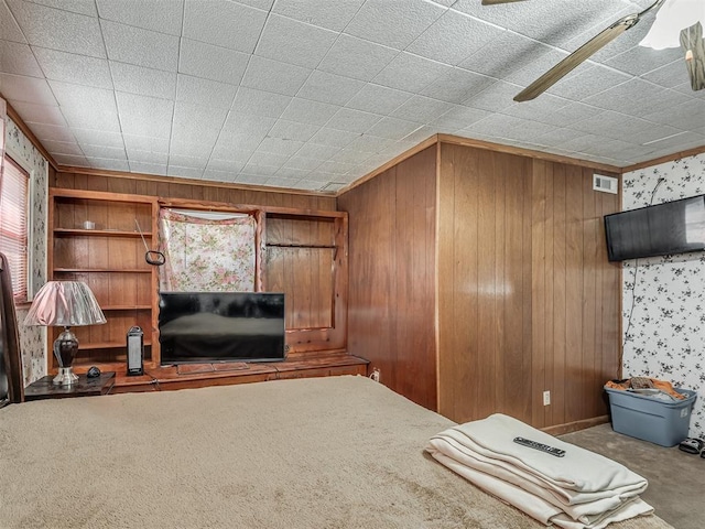 unfurnished living room with ornamental molding, visible vents, wooden walls, and carpet