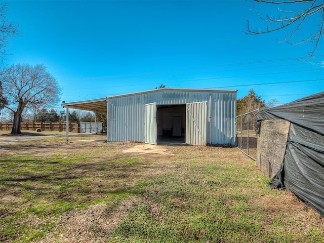 view of pole building featuring a yard and fence