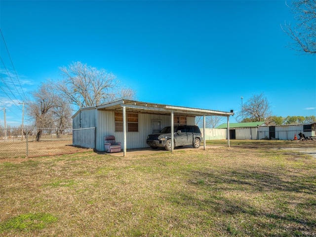 view of pole building with fence, a carport, and a yard