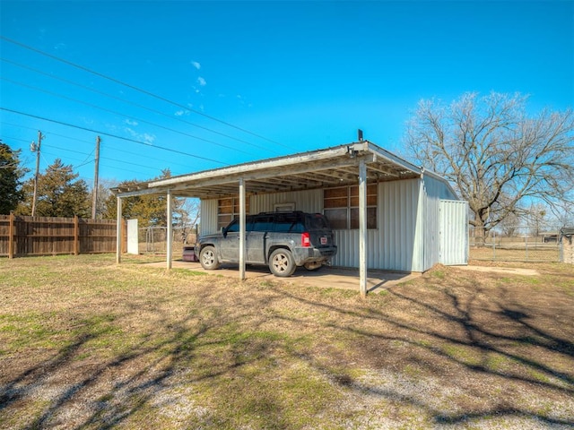 view of pole building featuring a yard, a carport, and fence