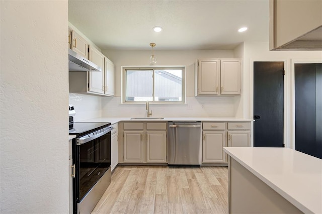 1804 Foxfire Rd, Edmond, OK 73003 - kitchen with a sink, light wood-style flooring, appliances with stainless steel finishes, light countertops, and under cabinet range hood