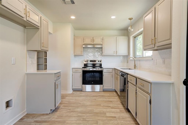 1804 Foxfire Rd, Edmond, OK 73003 - kitchen with a sink, decorative backsplash, light wood-style floors, appliances with stainless steel finishes, and visible vents