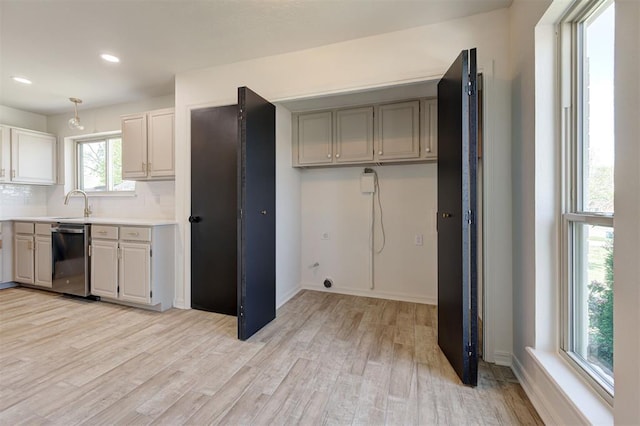 1804 Foxfire Rd, Edmond, OK 73003 - kitchen with stainless steel dishwasher, light wood-style flooring, a sink, recessed lighting, and light countertops